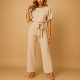 Elegant women’s jumpsuit with high waist and lace-up belt in soft draping fabric, perfect for work or casual chic occasions.