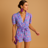Short jumpsuit for women with vibrant print and waist-accentuating belt, perfect for summer days or casual evening looks.