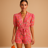 Short jumpsuit for women with vibrant print and waist-accentuating belt, perfect for summer days or casual evening looks.